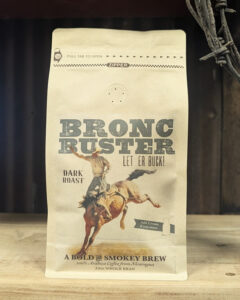 Bag of Bronc Buster dark roast whole bean coffee with smoky, chocolate, and pecan notes